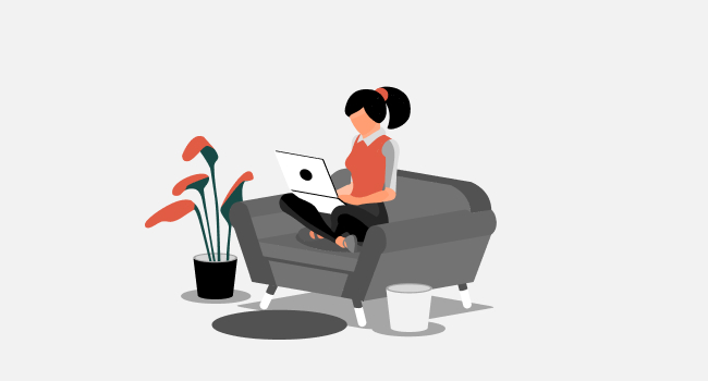woman with a laptop sitting on the sofa and working on a grey background